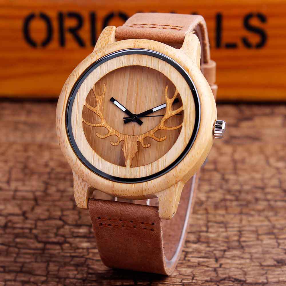 Wooden watch with deer antler design on a brown leather strap against a wooden background.