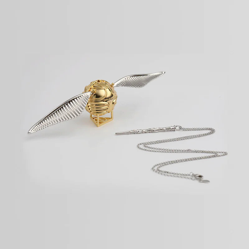 Gold and silver snake pendant with chain on a light gray background