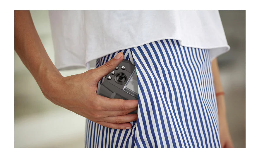 Person wearing blue and white striped shorts with a white shirt, holding a camera.
