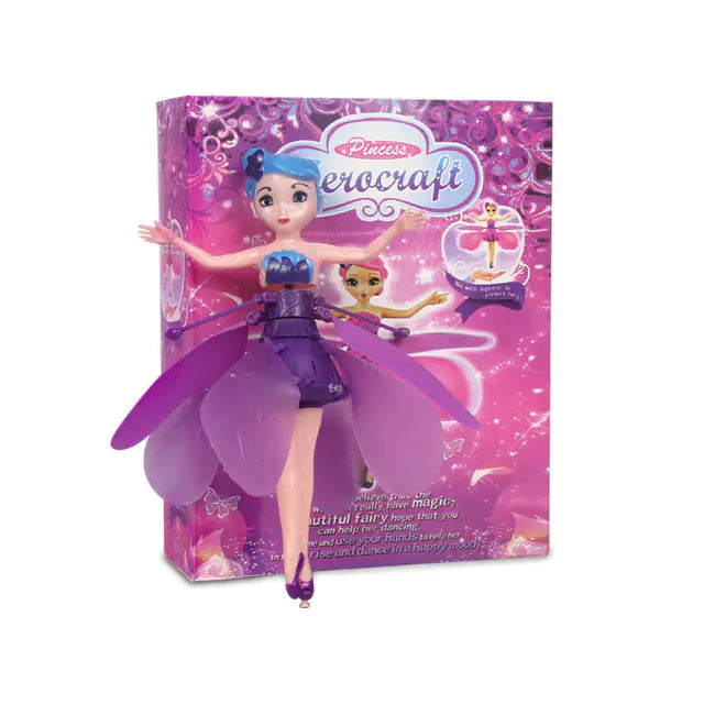 Fairy doll with purple outfit and wings in front of its packaging on a white background