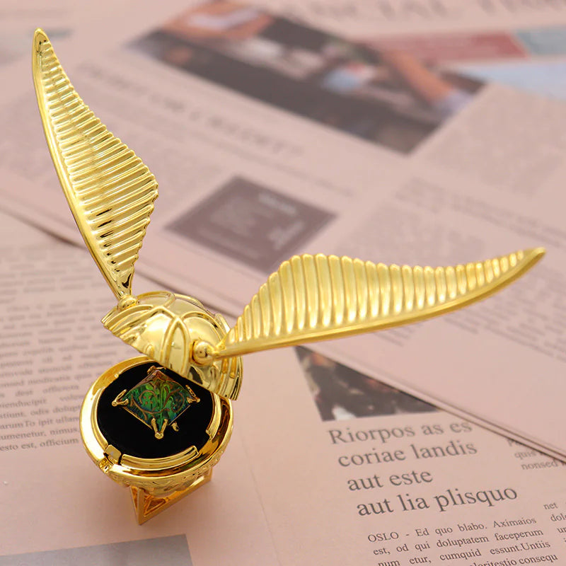 Gold brooch with wings on a newspaper background