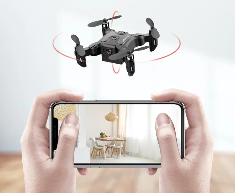 Drone flying above a smartphone displaying a room view, held by hands.