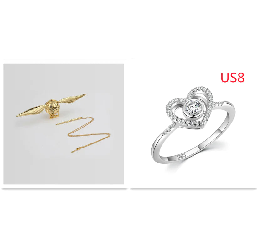 Gold snake-shaped earring and silver heart-shaped ring on a white background