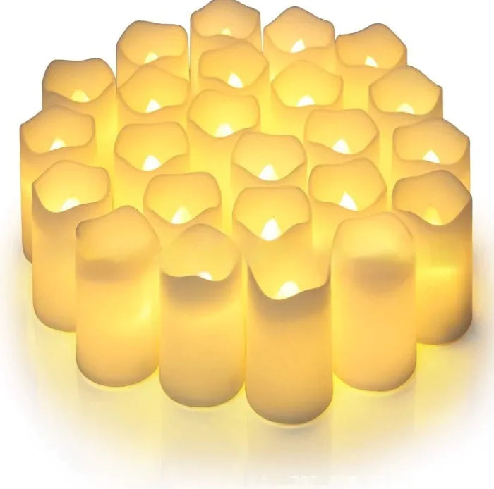 Set of small, lit candles with a soft glow on a white background