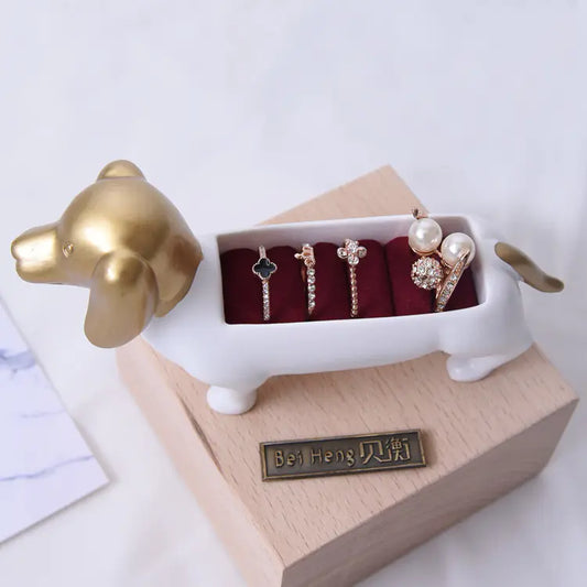 Dog-shaped jewelry holder with rings on a white background