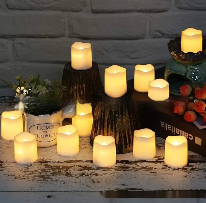 Flickering candles on a rustic wooden surface with decorative items against a stone wall background.