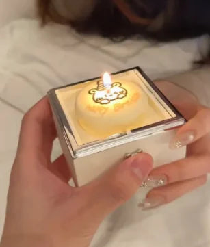 Candle in a decorative holder held by a person with a blurred background