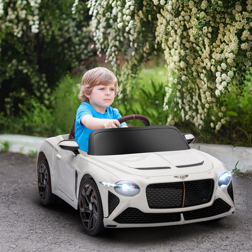 Child driving a toy Bentley car in a garden setting